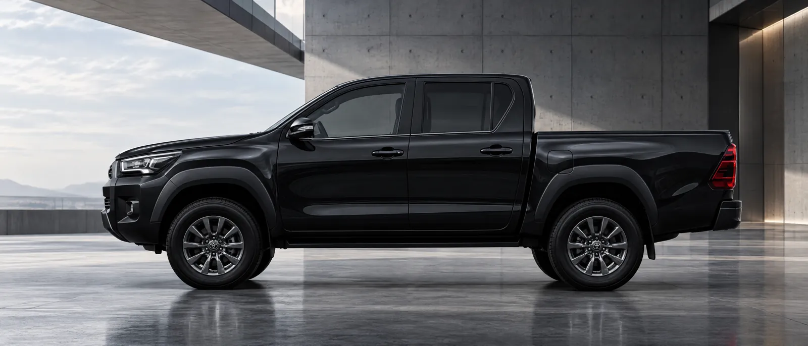Toyota Hilux negra de perfil en un espacio de arquitectura industrial
