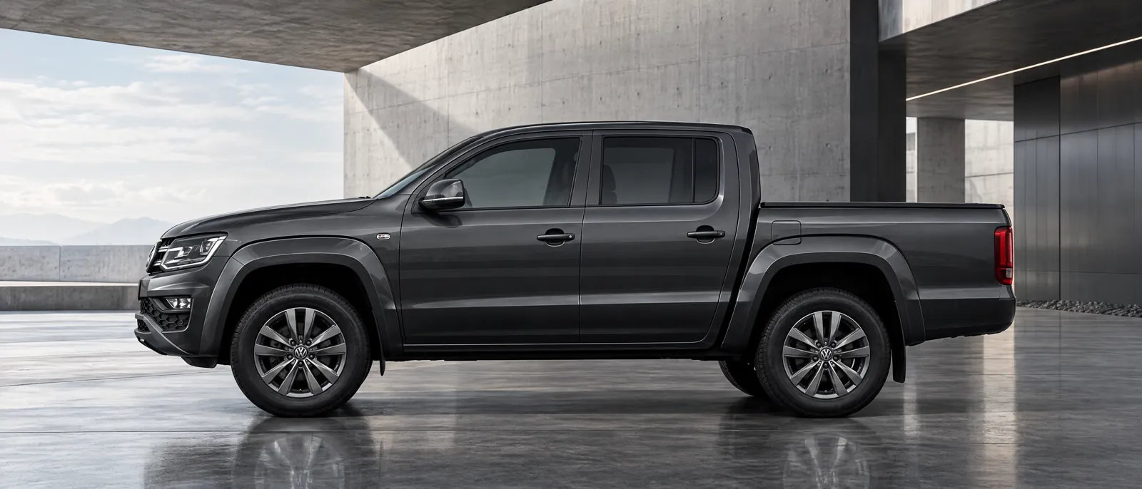 Volkswagen Amarok gris oscuro de perfil en un espacio de arquitectura industrial
