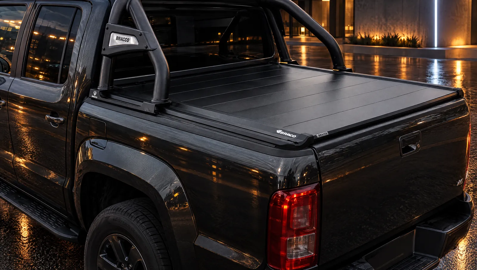 Tapa rígida plegable B-TANGO de Bracco con jaula, en una pickup de noche en un entorno urbano