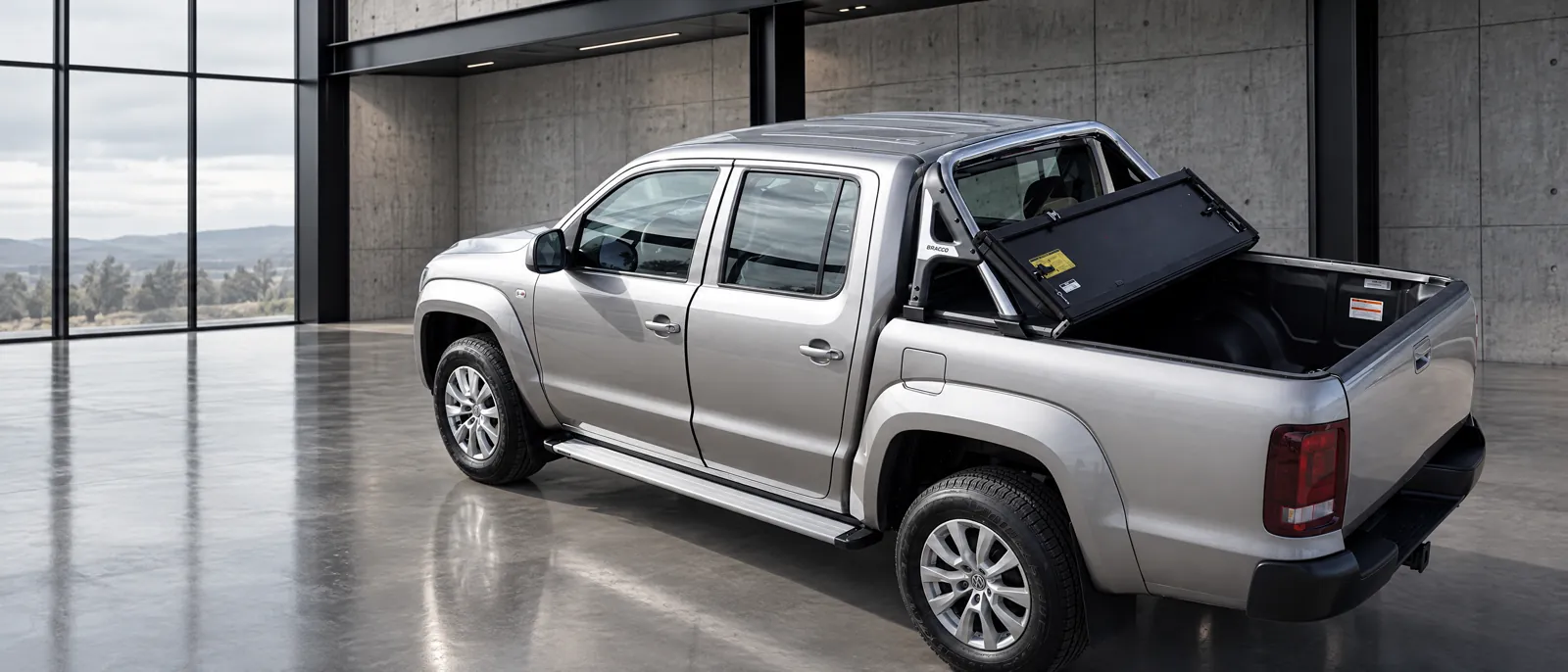 Volkswagen Amarok con tapa rígida rebatible Bracco abierta y jaula en un espacio de arquitectura industrial